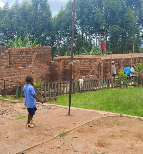 A child beside the walls of a classroom under construction